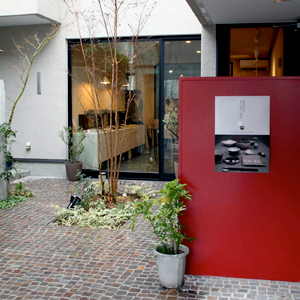 入り口前に目を引くベンガラ色の案内板がある写真